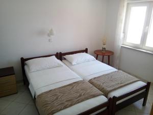 2 camas individuais num quarto com uma janela em Apartments with a parking space Lokva Rogoznica, Omis - 17395 em Lokva Rogoznica
