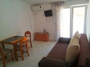 uma sala de estar com um sofá e uma mesa em Apartments with a parking space Lokva Rogoznica, Omis - 17395 em Lokva Rogoznica