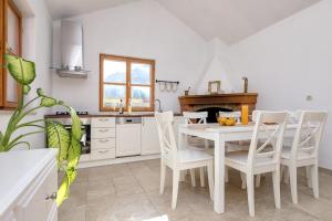 a kitchen with a white table and white chairs at Holiday house with a parking space Pitve, Hvar - 17397 in Jelsa