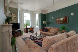 a living room with two couches and a tv at Highleigh House in Teignmouth