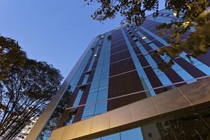 a tall glass building with a blue sky in the background at Living Sion in Belo Horizonte