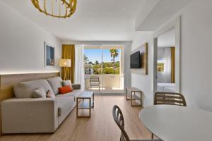 a living room with a couch and a table at Palmanova Beach Apartments by TRH in Palmanova