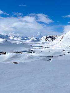 een met sneeuw bedekte bergketen met bergen op de achtergrond bij Fin leilighet med flott beliggenhet ski in ski out in Beitostøl