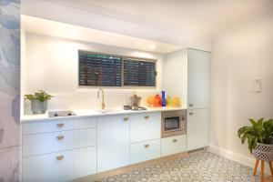a kitchen with white cabinets and a window at Lovestone Cottages Montville in Montville