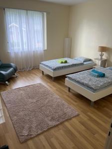two beds in a room with wooden floors at Casa Silvia in Gordevio