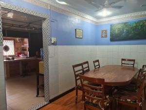 a dining room with a table and a kitchen at AnNur Homestay in Lahad Datu +6 photos