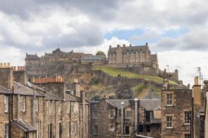 a castle on top of a hill with buildings at Amazing Castle View Apartment in Edinburgh