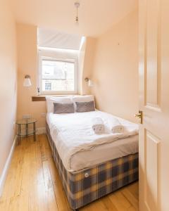 a bedroom with a large bed with a window at Amazing Castle View Apartment in Edinburgh