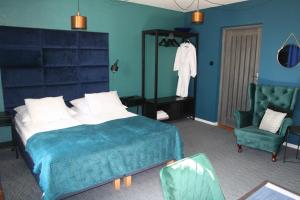 um quarto azul com uma cama e uma cadeira em Segment rodzinny Stara Szkoła em Weremowice