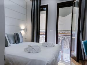 sypialnia z białym łóżkiem i balkonem w obiekcie B&B Vanity w Tropei