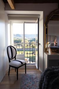 a bedroom with a chair and a large window at Casa Pepin in Polientes