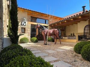 una estatua de caballo parada frente a una casa en Casa Pepin, en Polientes