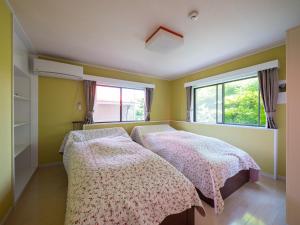 two beds in a room with two windows at Villa LIGHT HOUSE -館山 LIGHT HOUSE- ペット可 in Susaki