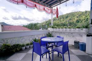 una mesa y sillas en un balcón con vistas en RedDoorz near Pantai Pandan Sibolga, en Halangan