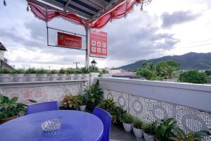 a table and chairs on a balcony with plants at RedDoorz near Pantai Pandan Sibolga in Halangan +15 photos