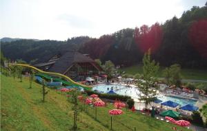 a resort with a large pool with slides and umbrellas at 4 Bedroom Amazing Home In Vrhnika in Vrhnika