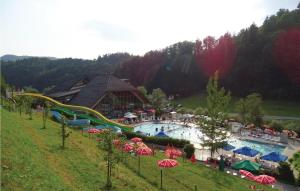 a resort with a large pool with slides and umbrellas at Awesome Home In Vrhnika With 4 Bedrooms And Wifi in Vrhnika