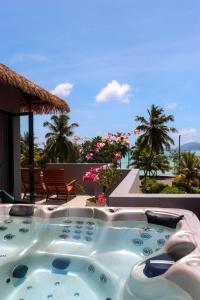 a hot tub on a patio with a view of the ocean at Blue Lagoon in Baie Lazare Mahé