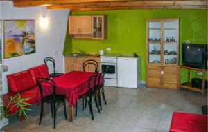 ノベ・バルプノにあるBeautiful Home In Nowe Warpno With 2 Bedrooms And Internetのキッチン、ダイニングルーム(赤いテーブル、椅子付)