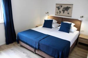 a bedroom with a large bed with blue and white pillows at Apartment Zrnovska Banja 17457b in Korčula
