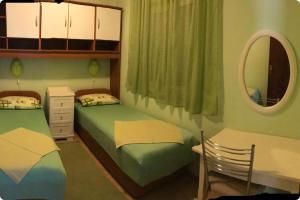 1 dormitorio con 2 camas individuales y espejo en Apartment Lopud 17200a, en Lopud Island