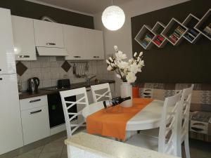 eine Küche mit einem Tisch und Stühlen sowie eine Küche mit weißen Schränken in der Unterkunft Apartment Lopud 17200a in Lopud Island