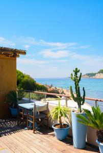 a wooden deck with a table and a view of the ocean at O Petit Monde in Sanary-sur-Mer