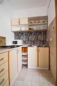 a kitchen with white cabinets and a tile wall at Studio Zadar 17553a in Zadar