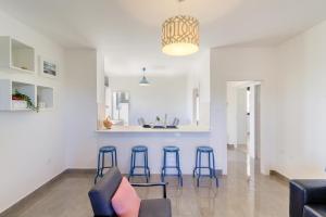 Apartments with a parking space Medulin - 17107 في ميدولين: مطبخ وغرفة معيشة مع كراسي زرقاء وبار