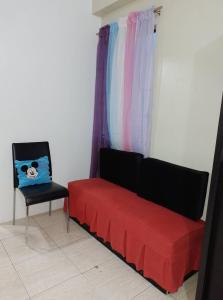 a living room with a red couch and a chair at Pet Friendly Condo for Rent in Valley Golf in Cainta