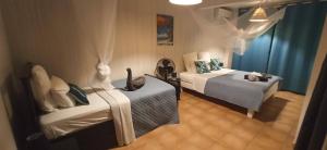 Villa CosaRoé Martinique Piscine et superbe vue mer في Rivière-Salée: غرفة نوم بسريرين وقط على السرير