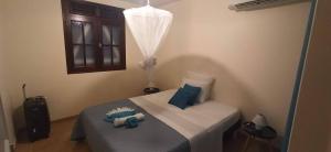 1 dormitorio con 1 cama con almohadas azules en Villa CosaRoé Martinique Piscine et superbe vue mer en Rivière-Salée