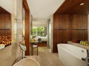 a bathroom with a white tub and a sink at Maya Sanur Resort & Spa in Sanur