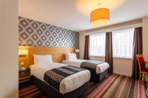 ニューカッスル・アポン・タインにあるHoliday Inn Newcastle-Jesmond, an IHG Hotelのベッド2台と窓が備わるホテルルームです。