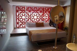 a bedroom with a bed and a red window at Hotel Amala in Mexico City