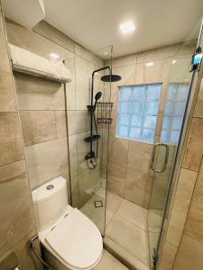 a bathroom with a toilet and a glass shower at Rayong Condo Chain studio room in Ban Pak Khlong Phe