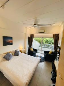 a bedroom with a large bed and a living room at Rayong Condo Chain studio room in Ban Pak Khlong Phe