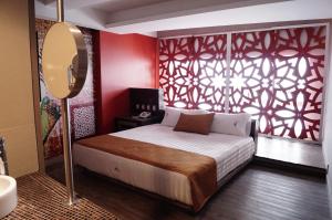 a bedroom with a bed and a red wall at Hotel Amala in Mexico City