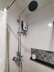 a shower with a shower head in a bathroom at Leez Inn Makati in Manila