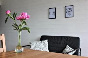 eine Vase rosafarbener Blumen auf einem Tisch in der Unterkunft Studio au cœur des Vosges avec une magnifique vue in La Bresse