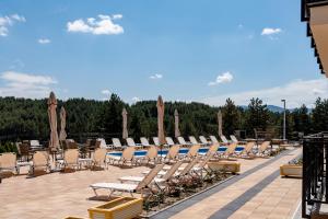 a row of lounge chairs and umbrellas on a patio at Monix Palace Zlatibor in Zlatibor
