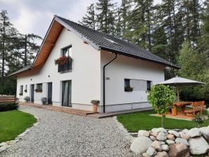 una casa blanca con techo negro en Apartmány Runi, en Stará Lesná