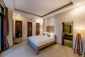 a bedroom with a bed and a television in it at Green Oasis Private Villa in Ubud