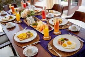a table with plates of breakfast food on it at Green Oasis Private Villa in Ubud