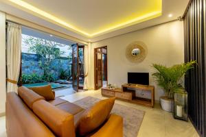 a living room with a couch and a television at Green Oasis Private Villa in Ubud