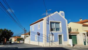 un edificio azul y blanco al lado de una calle en A Casinha en Caldas da Rainha