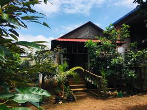 a house with a bunch of plants in front of it at Ratanakiri Farmhouse & Trekking in Banlung