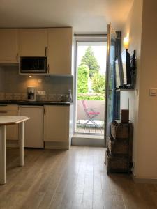 cocina con mesa y puerta a un patio en studio 6 Versoie avec parking, en Thonon-les-Bains