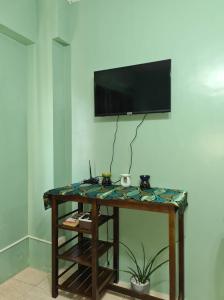 Zimmer mit einem Tisch und einem TV an der Wand in der Unterkunft Affordable Condo for Rent along Ortigas Extension in Cainta