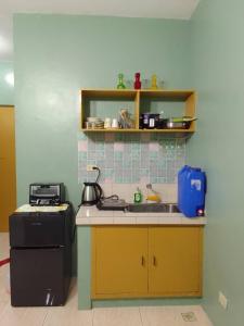 eine kleine Küche mit Spüle und Herd in der Unterkunft Affordable Condo for Rent along Ortigas Extension in Cainta